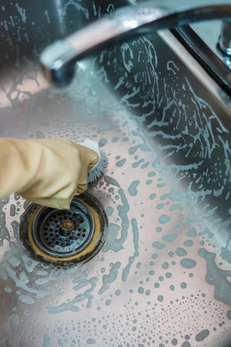 Drain cleaning — drain auger clearing a clogged household drain